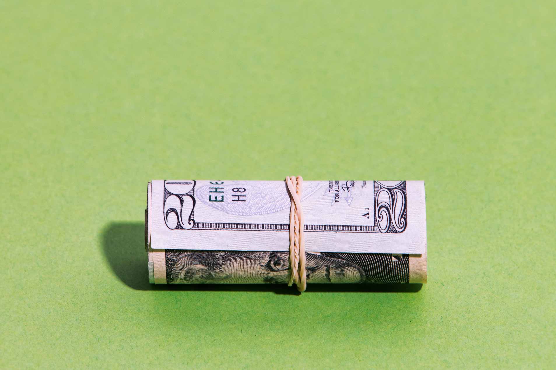 Images of money on a uniform green background.